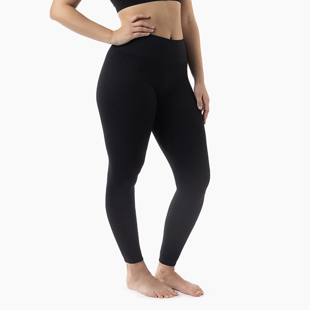 Person wearing black leggings on a white background