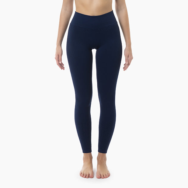 Person wearing navy blue leggings on a white background