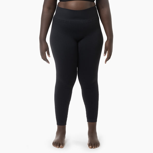 Person wearing black leggings on a white background