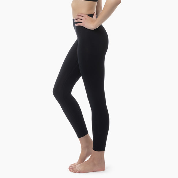 Person wearing black leggings on a white background