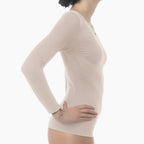 Beige long-sleeve top worn by a person on a white background