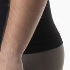 Person wearing black underwear with a neutral background