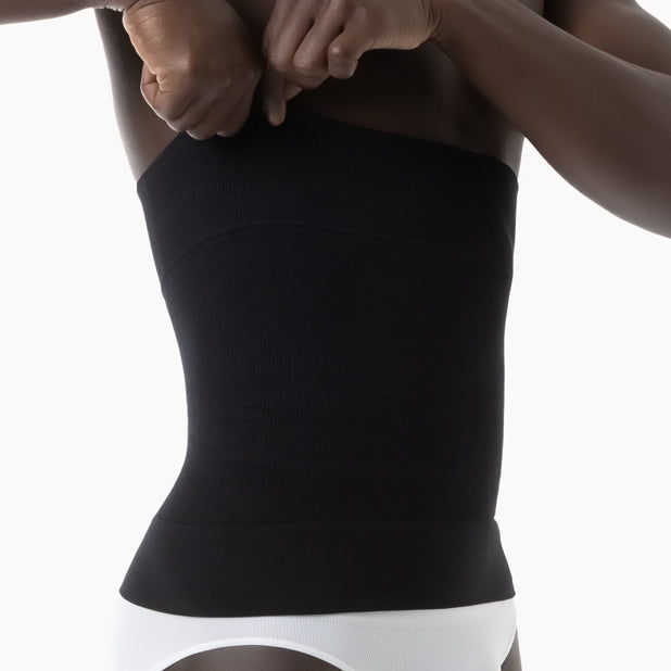 Person wearing a black waist trainer against a white background