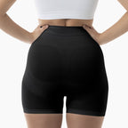 Black high-waisted shorts worn by a person on a white background