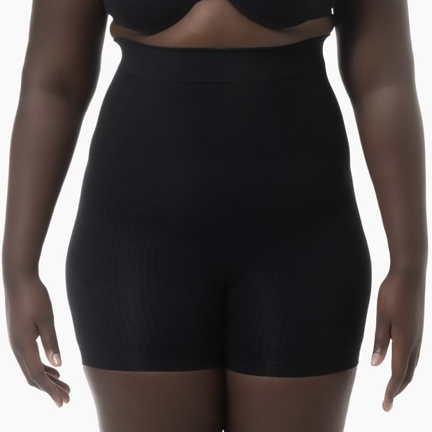 Black shapewear shorts worn by a model on a white background