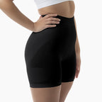 Black athletic shorts worn by a person on a white background