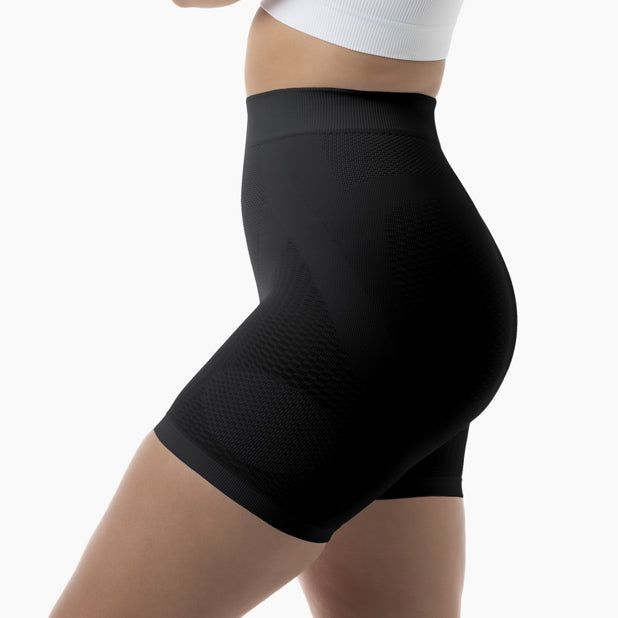 Black high-waisted compression shorts worn by a person on a white background