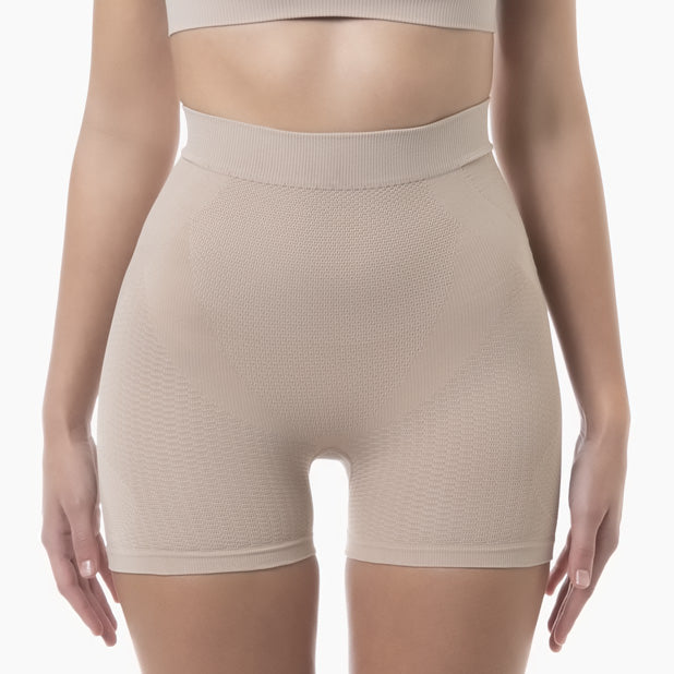 Beige shapewear shorts worn by a person on a white background