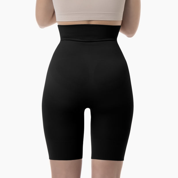 Black high-waisted shapewear shorts worn by a person on a white background