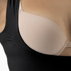 Close-up of a black tank top and beige bra.