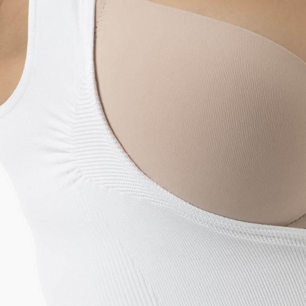 Close-up of a white tank top with beige bra underneath