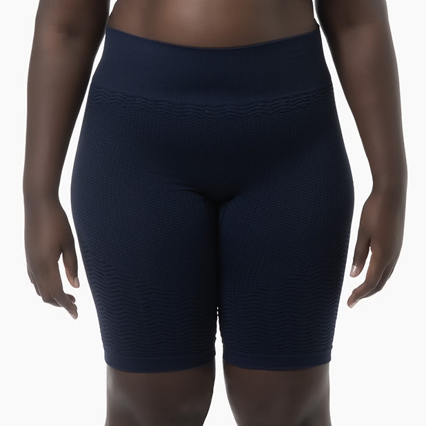 Navy blue athletic shorts worn by a person on a white background