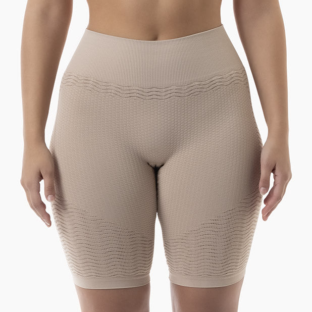 Beige compression shorts worn by a person on a white background