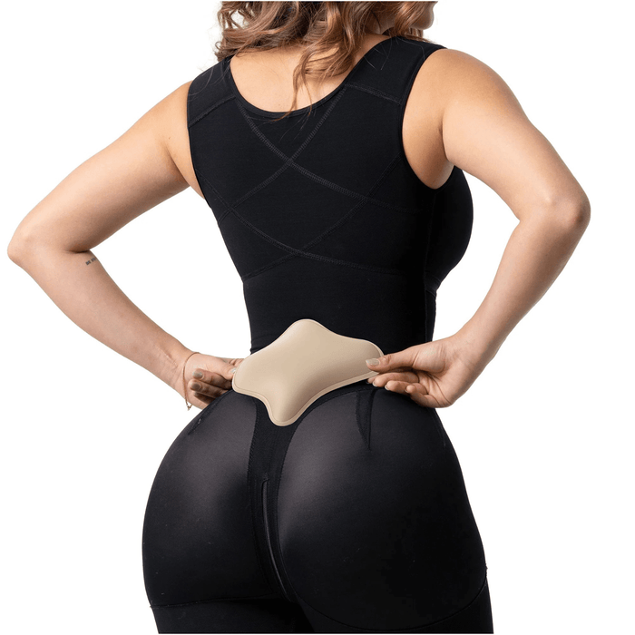 Woman wearing black shapewear holding lumbar compression board for post-surgery back support
