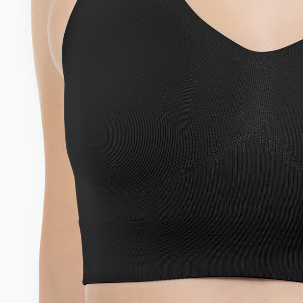 Black sports bra worn by a person on a white background