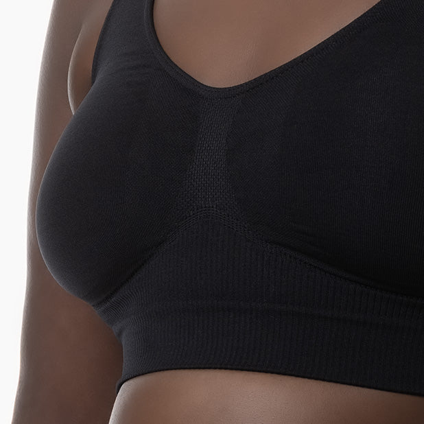 Black sports bra worn by a person on a white background