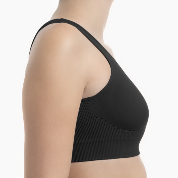 Black sports bra worn by a person on a white background