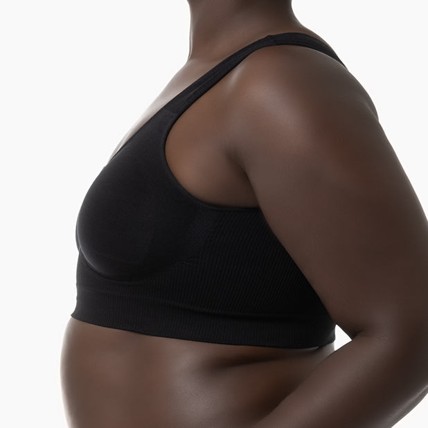 Black sports bra worn by a person on a white background