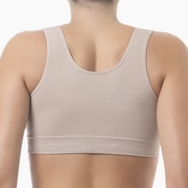 Beige sports bra worn by a person on a white background