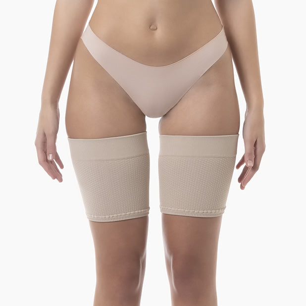 Beige compression stockings worn by a person on a white background