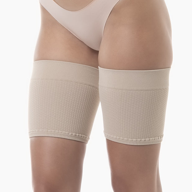 Beige compression stockings worn by a person on a white background