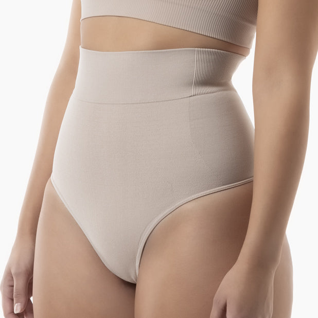 Beige high-waisted underwear worn by a person on a white background