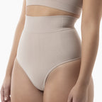 Beige high-waisted underwear worn by a person on a white background