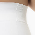 Close-up of a white ribbed garment on a neutral background