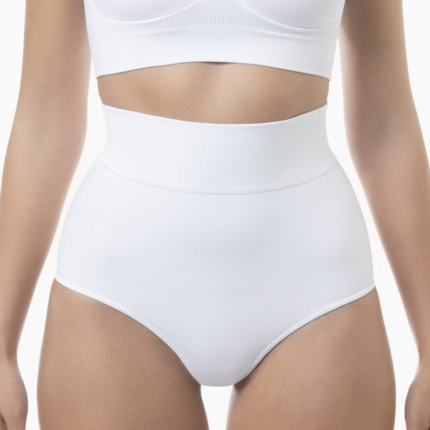 Person wearing white high-waisted underwear and a white crop top on a light background