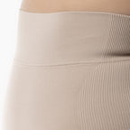 Close-up of beige ribbed leggings on a neutral background