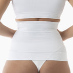 Person wearing a white high-waisted skirt and crop top on a light background